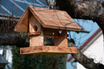 wooden Homemade Bird's Feeder On The winter Tree in the garden