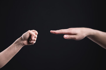 Game stone paper scissors on a dark background. The male and female hand are competing. Business competition