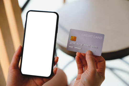 Close up of women's hands holding cell telephone and credit card with blank copy space scree for your advertising text message or promotional content, shoping online.