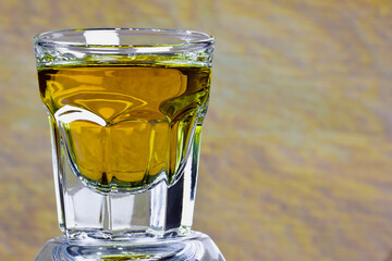 On a beige background on the left side of a glass with whiskey close-up. On the right is a place for an inscription