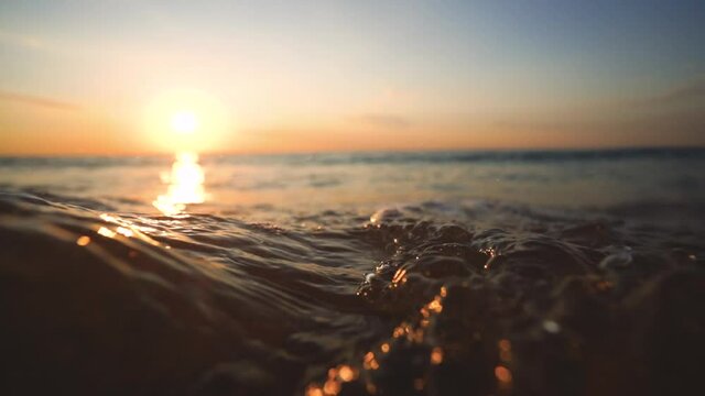 Sea sunrise and splashing waves on the sand, 4K video