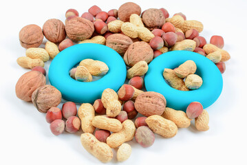 Mixture of nuts with simulator for hand by an expander. The concept of sports nutrition and diet for weight loss.