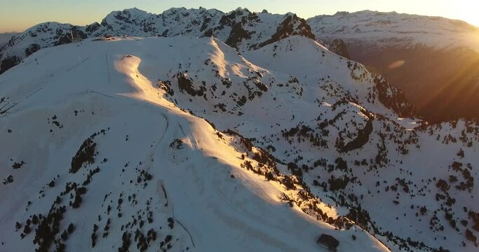 Ski resort summit track at Chamrousse in the French Alps with shelter cabin and ski lift line, Aerial orbit left shot