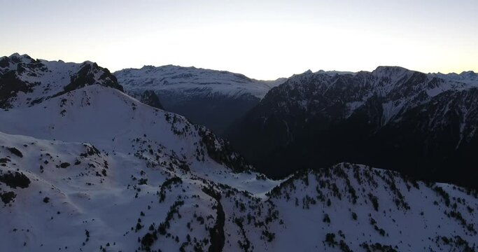 Rugged snowed peaks of the French Alps at Chamrousse before sunrise, Aerial dolly right shot