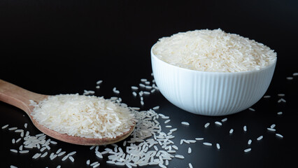 Jasmine rice, popular rice variety in Thailand. Rice grain that has passed through the polishing process Ready to be cooked or steamed. White seeds on black background.