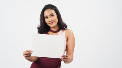 Naklejka premium empty blank paper in Asian woman's hand . A studio portrait with white background .Empty Space for text .She have tan skin.