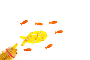 Omega-3 fish oil capsules in a shape of a fish on white background