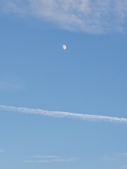 Clouds and moon floating in a clear sky