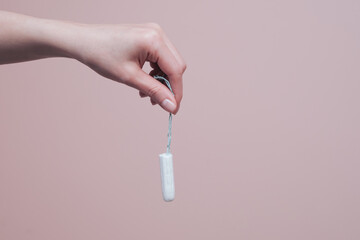 Hand holding clean cotton tampon. Women hygiene and health concept with copy space