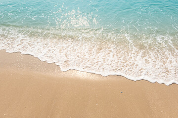 Fototapeta na wymiar Blue ocean waves Sunlight Reflection Sand Beach background