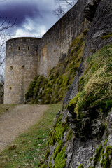 Fototapeta na wymiar View on old castle wall under dark clouds 