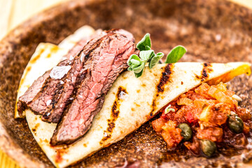 Flank steak with tortilla and vegetables. Food styling for street food. Closeup.