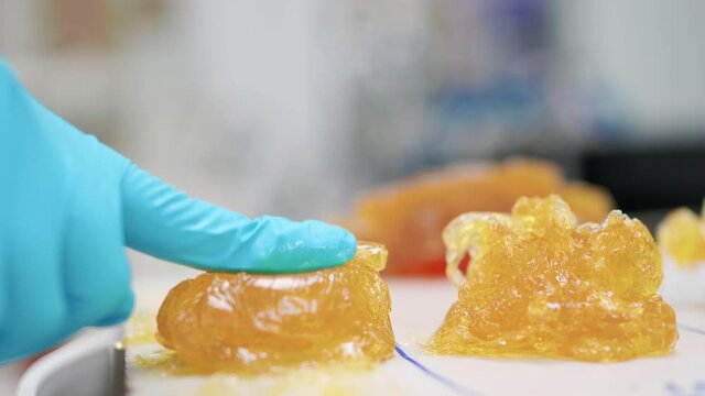 Technician testing the texture of lithium grease NLGI 3 by using two fingers press on the grease and see the stickiness and appearance in the laboratory. Wearing nitrile glove. Testing and quality