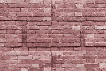 A wall of old, cracked bricks, with a weathered and faded surface. Restored brickwork of an old house.
