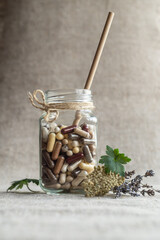 Cocktail of capsules with food supplements in glass jar