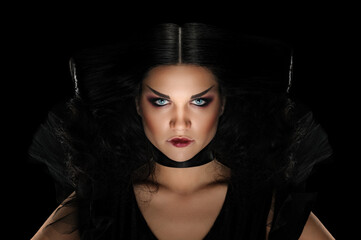 Beautiful young female with mysterious makeup on dark background