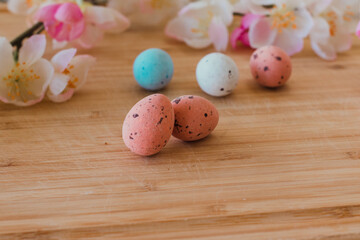 Obraz na płótnie Canvas Easter eggs coroluf on a wooden table with flowers
