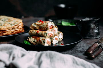 Thin pancakes with herbs, salmon and cream cheese on a plate. crepes