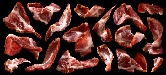 Sliced bacon on black background, raw ham strips