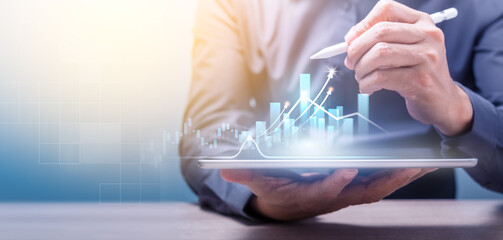 Businessman holding tablet and point to chart on virtual screen. Business strategy abstract graphic background and Digital marketing of sales and economic growth graph chart