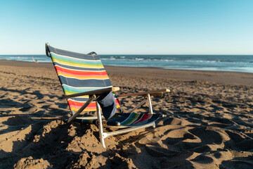 Fototapeta na wymiar Relaxing chair on the beach. Concept of vacation, travel, and relaxation.