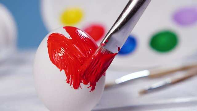 Painting Easter Eggs with a Red brush, Preparation for spring holiday, Religious celebration, Art Colorful Concept