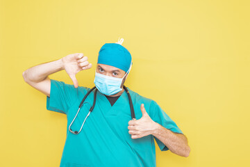 Surgeon dressed in operating theatre uniform and stethoscope, on yellow background.