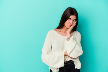Young caucasian woman isolated on blue background who feels sad and pensive, looking at copy space.