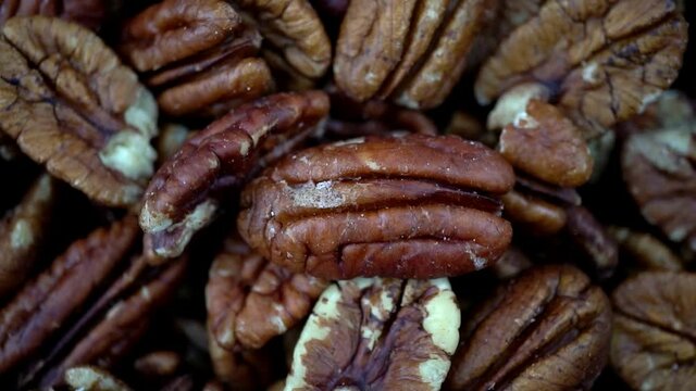 Slow motion rotation top down footage of pecan nuts. Pecan macro flat lay footage spinning in slow motion.