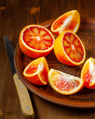 Sicilian blood orange on wooden background. Blood orange juice with ice and orange slice.