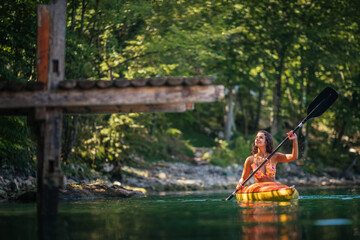 Female in bikini kayaking on lake during sunny day