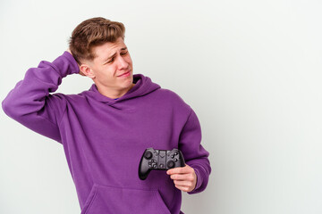 Young caucasian man holding a gamepad isolated on white background touching back of head, thinking and making a choice.