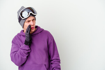 Young man holding a snowboard board isolated on white background is saying a secret hot braking news and looking aside