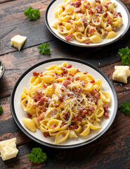 Classic Pasta carbonara with bacon, egg, cream, black pepper and Parmesan Cheese on plate. Italian food