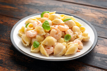 Italian conchiglie prawn, shrimp pasta in a creamy sauce on plate.