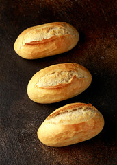 Freshly baked bread buns on rustic table