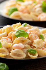 Italian conchiglie prawn, shrimp pasta in a creamy sauce on plate.