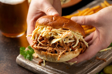 Homemade BBQ Pulled Pork burger with coleslaw, fries and beer