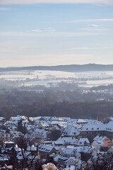 Fototapeta na wymiar View of snow-covered Fulda with sights like the Fulda Cathedral and Fulda Castle from the Frauenberg Monastery in february 2021