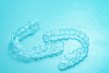 Invisible dental teeth brackets tooth aligners on turquoise background. Plastic braces dentistry...