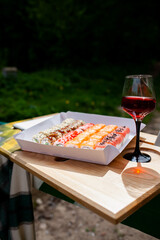 Delicious colorful sushi rolls and a glass of white in nature