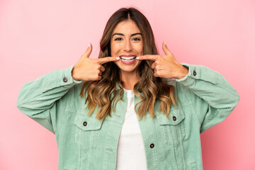 Young caucasian woman isolated smiles, pointing fingers at mouth.