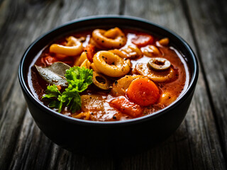 Tomato soup with noodles on wooden table
