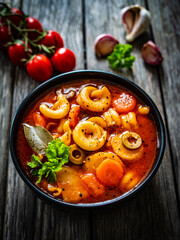 Tomato soup with noodles on wooden table
