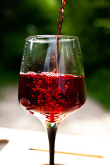 a large glass of red wine with splashes and bubbles. copy space,similar images