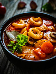 Tomato soup with noodles on wooden table
