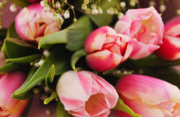 Bouquet of pink tulips with green leaves.