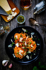 Spaghetti a'la bolognese with minced pork meat and parmesan on wooden table