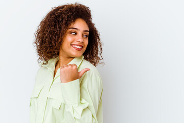 Young african american woman isolated on white background points with thumb finger away, laughing and carefree.