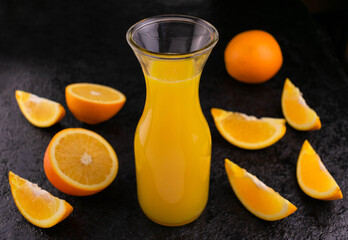 Orange juice in a bottle on a black background. Top view.